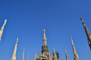 Nadia Mikushova. View to the golden Madonnina of Milan sculpture and the spires of Duomo. 